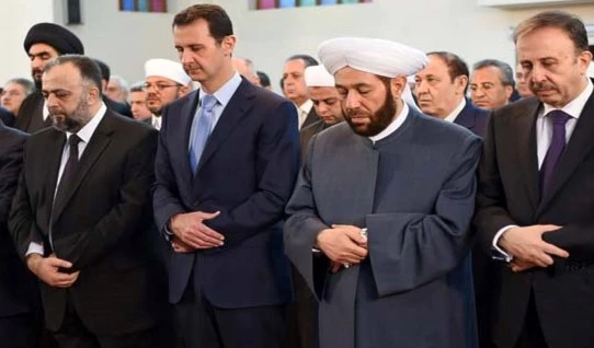 الأسد وإلى يساره مفتي سوريا ورئيس مجلس الشعب الأسد وإلى يساره مفتي سوريا ورئيس مجلس الشعب