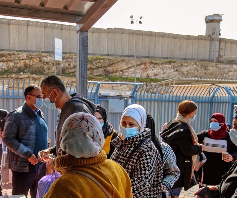 فلسطينيون ينتظرون على حاجز إسرائيلي قرب رام الله دورهم لتلقي لقاح كورونا. فلسطينيون ينتظرون على حاجز إسرائيلي قرب رام الله دورهم لتلقي لقاح كورونا.