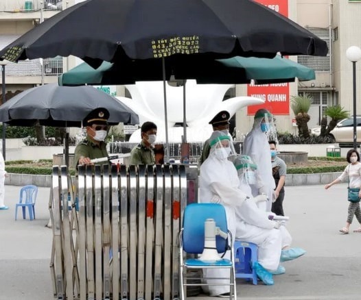 عاملون طبيون يرتدون بدلات واقية خارج مبنى خاضع للحجر الصحي في هانوي عاملون طبيون يرتدون بدلات واقية خارج مبنى خاضع للحجر الصحي في هانوي