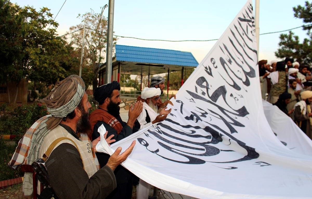 Taliban fighters pray while raising their flag at the Ghazni provincial governor’s house, in Ghazni, southeastern, Afghanistan, August 15, 2021 | AP