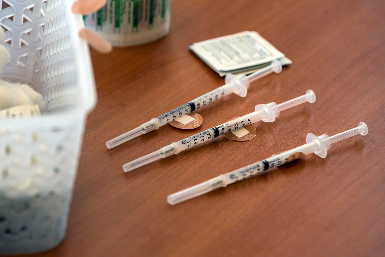 Three COVID-19 vaccine shots are shown on a table | AP